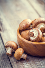 Mushrooms in wooden bowl on table. Selective focus.