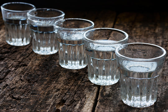 glasses of vodka on a wooden background