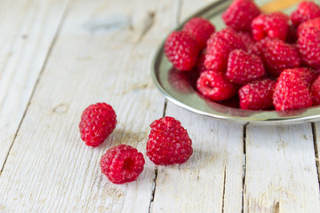 Спелая малина на деревянном фоне.