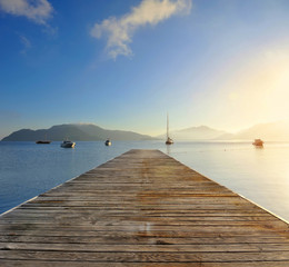 Obraz na płótnie Canvas Sunrise over the pier on the Aegean Sea, morning at the sea berth