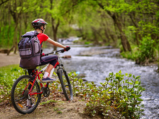 Bikes cycling girl. Girl with big rucksack rides bicycle. Girl cycling fording throught water . Cycling trip is good for health. Cyclist is looking throught river.