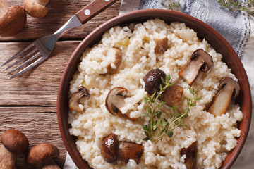 Italian rice with wild mushrooms close up on the table. Horizontal top view    © FomaA