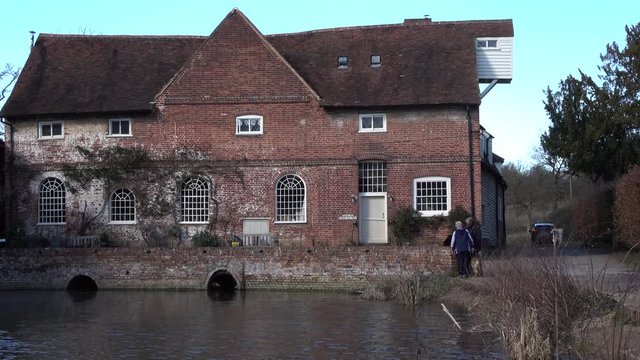 Flatford England historic landmark nature preserve. Flatford Mill watermill built in 1733 on the River Stour, Suffolk, England. 17th century miller's cottage. Typically English rural landscape.