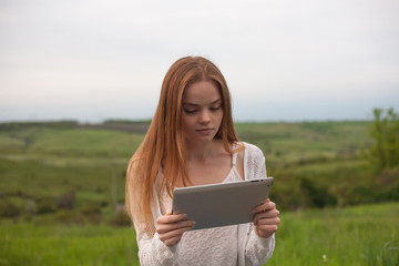 Young smiling woman with laptop in park.