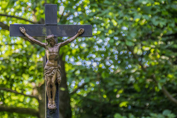 Ein Jesuskreuz steht im Wald