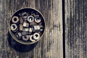 Nuts in a tin can on wooden board background