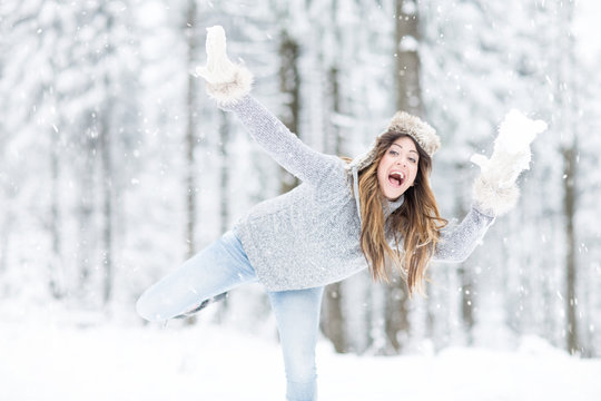 Frau wirft schneeball im winter