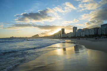 Fototapeta premium Złote słońce za sylwetką panoramę Rio de Janeiro w Brazylii na końcu Leme plaży Copacabana