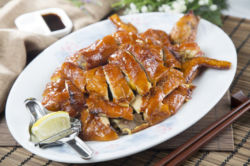 Chinese chopped grilled chicken on white plate on the table in restaurant