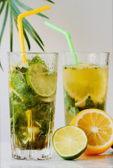 Two glasses of cold lemonade with ice, lime and lemon