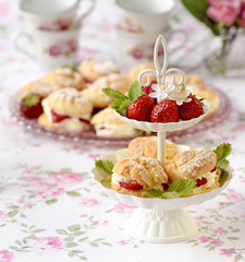 Homemade cream puffs or profiterole filled with whipped cream served with strawberries in plateau