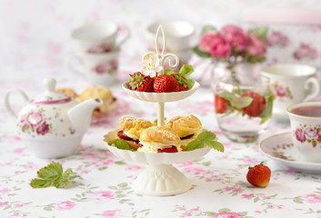 Homemade cream puffs or profiterole filled with whipped cream served with strawberries in plateau