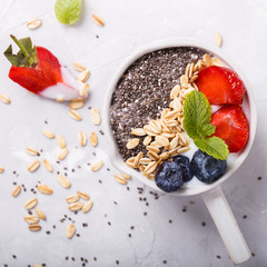 Yogurt and oatmeal with fresh berries,Chia seeds and mint on a white background.Granola,a healthy Breakfast.selective focus.