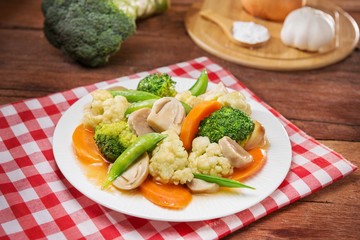 Plate of fried vegetables with cauliflower, mushroom, carrot and green beans on the table in restaurant