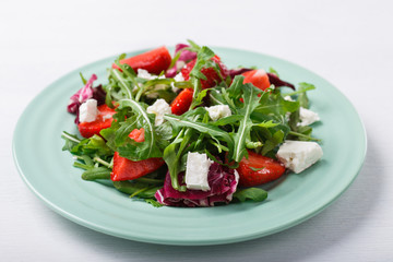 Salad of fresh strawberries,arugula,lettuce with pieces of cheese.selective focus.