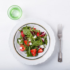 Salad of fresh strawberries,arugula,lettuce,cheese and sesame seeds .healthily cooking concept.selective focus.