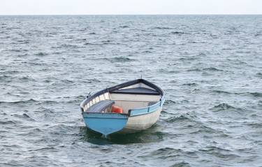Naklejka premium Lonely empty boat on rough water