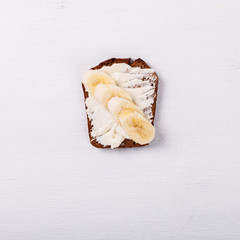 Sweet sandwich with cream-cheese and banana over a white background . Top view. healthy breakfast.Copy space.selective focus.
