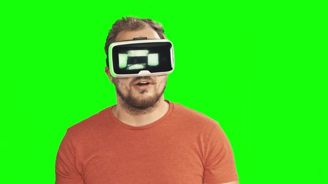 Young man wearing virtual reality VR glasses / googles. Isolated on Greenscreen 