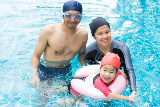 Little baby in an early swimming class with family