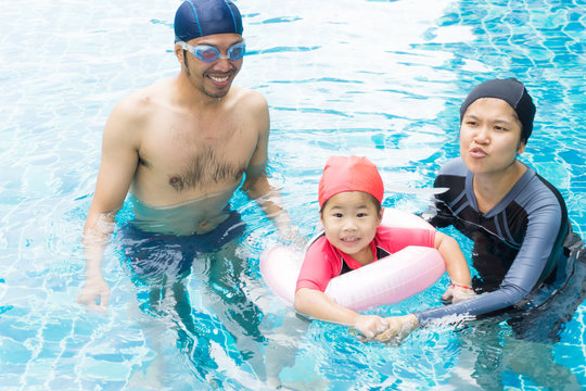 Little baby in an early swimming class with family