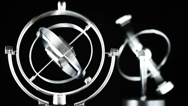 Close up of Newton's Cradle, Desk toy pendulum being activated, black background