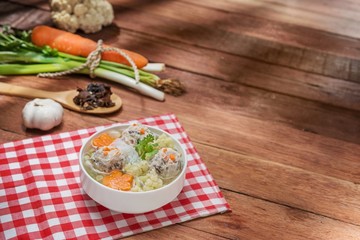 Plate of soup with meat ball and cauliflower and vermicelli on the table in restaurant