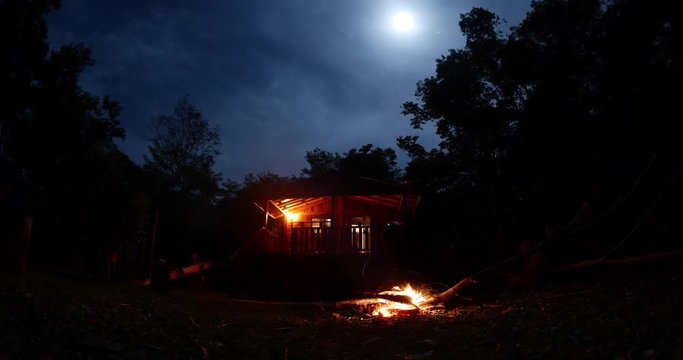 Punta Gorda, Belize - May, 2016 - Timelapse of a bonfire in front of a wooden cabin in the woods.