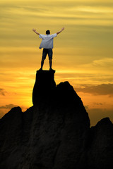 Winner man standing on the top of mountain