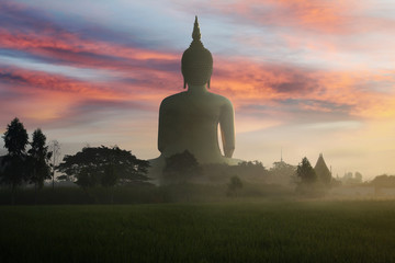 Big golden buddha statue of Thailand at Wat Maung and .natural background of the colorful sky and...