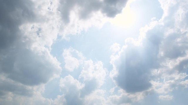 Cumulus clouds trying to grow to higher altitudes, moving across the beaming sun, time lapse