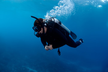 Scuba diver exploring deep reef.
