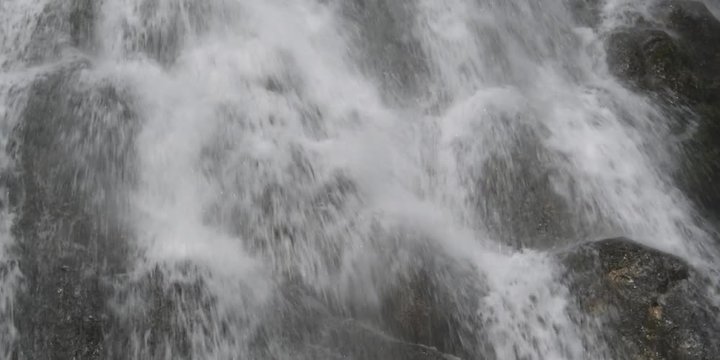 Close-up of a waterfall cascading among rounded rocks
