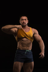 handsome muscular bodybuilder posing on a black background