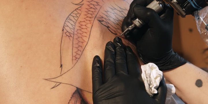 Close-up of a tattoo being inked onto a woman's back
