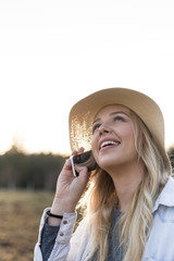 young smiling girl  with hat using a phone, talking