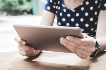 Asian woman using tablet pc on a wood table