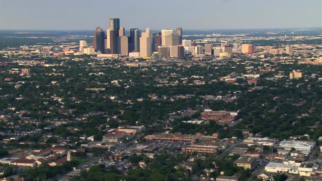Wide flight over outlying areas past distant downtown Houston. Shot in 2007.
