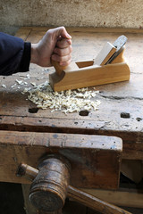 Carpenter's hand in the carpentry workshop with a plane