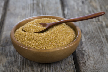 Sugar and spoon in a wooden bowl