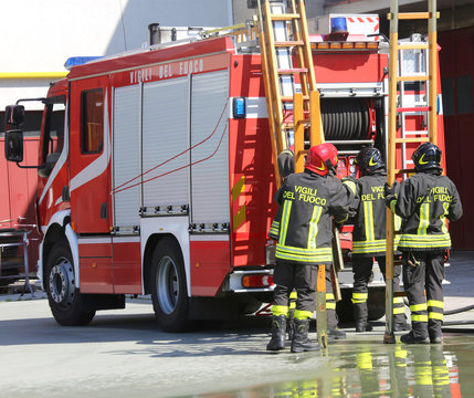firefighters in action take the wooden ladder from the firetruck