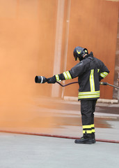 Fireman with an extinguisher under the Orange smoke