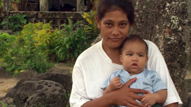 Young Samoan Woman And Baby Seated By Tree