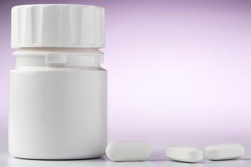 Bottle of aspirin drugs and three pills in the foreground