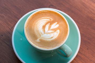 cup of coffee late art on dark wood background
