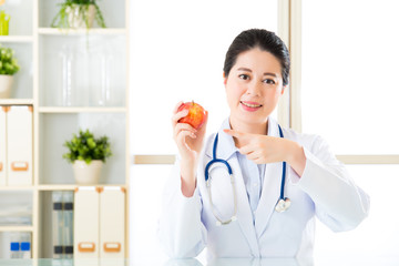 Young asian nutritionist recommend eating apple