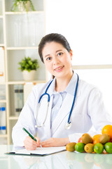 Young asian nutritionist doctor writing diet plan