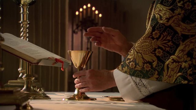 Priest elevating the chalice of wine during Eucharist