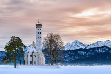 Fototapeta na wymiar St. Coloman church at sunset on a winter day with snow and frost