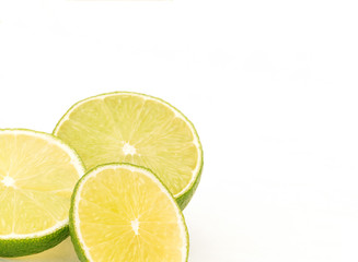 Fototapeta na wymiar Three slices of lime on white background in bottom left corner